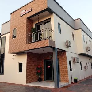 Agape Villa Luxury Apartments في بنين سيتي: مبنى مع شرفة وباب