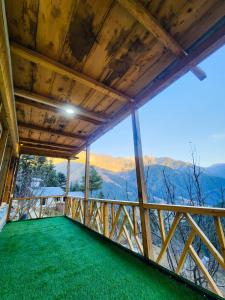 a view from the balcony of a cabin with green grass at Winterfell Cottages - Edition Tandi in Jibhi