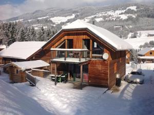 a log cabin in the snow with snow covered at Woody Park Chalet 14 in Kaindorf