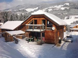 uma cabana de madeira na neve com neve coberta em Woody Park Chalet 14 em Kaindorf