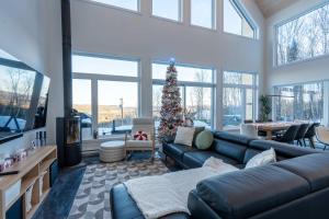 a living room with a christmas tree and a couch at Chalet Le Valkea - Spa & Mountain in Saint Come