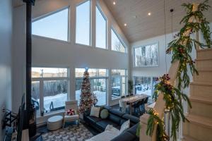 a living room with a christmas tree and a couch at Chalet Le Valkea - Spa & Mountain in Saint Come