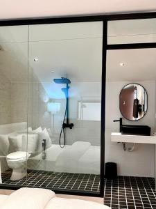 a bathroom with a glass shower with a toilet at The Heritage 1937 in Kuching