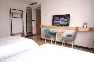Ένα ή περισσότερα κρεβάτια σε δωμάτιο στο City Comfort Inn Huizhou Zhongkai Huitai Industrial Park