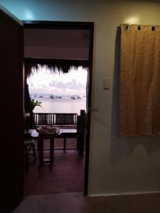 een deur naar een kamer met uitzicht op de oceaan bij Kimura Beachfront Villas El Nido in El Nido +25 foto's