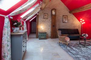 een woonkamer met rode muren en een bank bij les gites du verger in Recey-sur-Ource