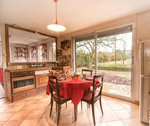a kitchen with a table with a red table cloth at les gites du verger in Recey-sur-Ource