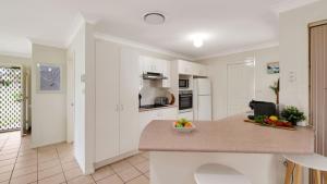 a kitchen with a counter with a bowl of fruit at The Coastal Corner in Culburra Beach