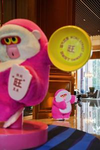 Le Meridien Emei Mountain Resort في إيمايشان: حيوانان محشوان يجلسان على طاولة مع قرص فريسبي