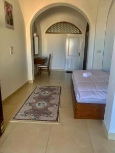 um quarto com uma cama, uma mesa e um tapete em Sunshine Divers Shark's Bay em Sharm El Sheikk