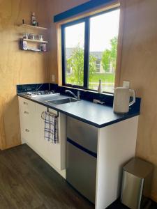 a small kitchen with a sink and a window at Watkins Tiny Retreat in Rangiora