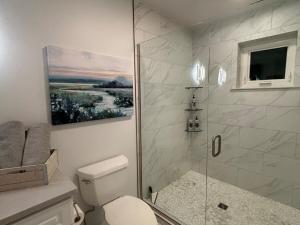 a bathroom with a shower with a toilet and a painting at Mississippi waterfront getaway-Dogs Welcome! in Brownsville +50 photos