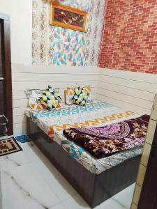 Walkinn Homestay Near TAJ MAHAL في Tājganj: سرير مع وسائد ملونة عليه في غرفة