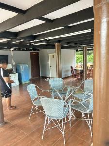 un uomo in piedi in una stanza con sedie e un tavolo di Siri Riverside 