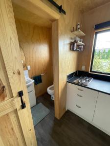 a small bathroom with a toilet and a sink at Watkins Tiny Retreat in Rangiora