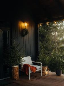 Un banco blanco sentado en un porche con una linterna. en Noma Cabin, en Măguri 2 fotos más