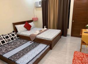 two twin beds in a room with at Piccadilly Green Villas Apartment in Dauis