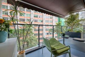 a balcony with a table and chairs and a building at Xiamen Puyiju Movie Theme Hotel in Heshan