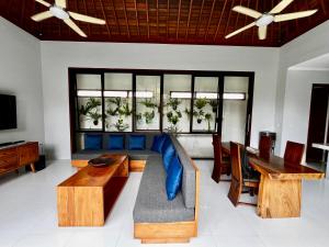 a living room with a blue couch and a table at Villa Mesari Sanur in Sanur