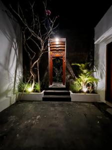 a hallway with a door and stairs at night at Villa Mesari Sanur in Sanur