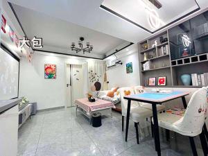 a living room with a table and a couch at Xiamen Puyiju Movie Theme Hotel in Heshan