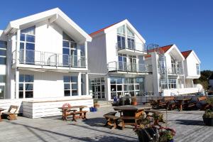 a group of white buildings with tables and benches at Hummeren Hotel in Tananger