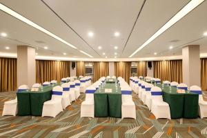 Lavande Hotel Changsha South High-speed Railway Station Xiyingmen في تشانغشا: قاعة احتفالات بطاولات وكراسي خضراء وبيضاء