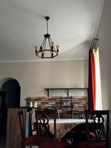 een eetkamer met een tafel en een kroonluchter bij Vintage Villa Mtskheta in Mtskheta