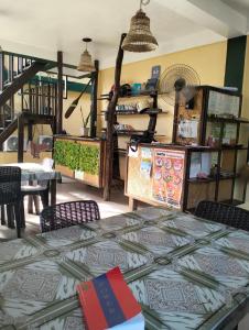 Eddie`s Beach Resort Siargao في جنرال لونا: غرفة مع طاولة وكراسي ورفوف +158 صورة