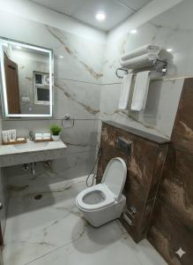 a bathroom with a toilet and a sink and a mirror at Expo Residency Inn in Jāmb