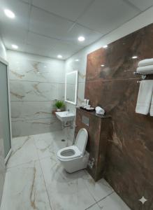 a bathroom with a toilet and a sink at Expo Residency Inn in Jāmb