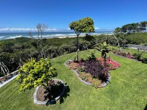 a garden with flowers and plants on the grass at Huis Seenekal in Cannon Rocks