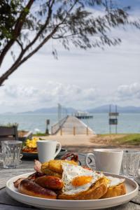 un piatto di prodotti per la colazione con vista sull'oceano di Picnic Bay Hotel a Picnic Bay