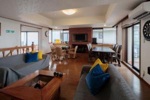 a living room with a couch and a table at 熱海絶景温泉宿 kintsugi 宙 in Wada