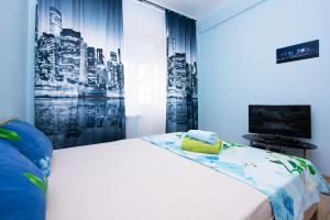 a bedroom with a large bed with a tv and a window at Apartlux Krasnopresnenskaya in Moscow