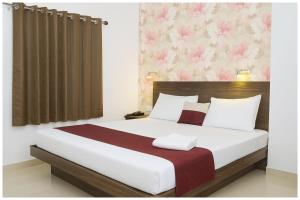 a bedroom with a large white bed with a brown curtain at Kanha Classic Inn Near Lucknow Railway Station # Free Wifi # Room Service And Parking Facility - Fully Air conditioning Premium Room - Best Premium Hotel In Lucknow in Lucknow