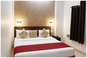 a bedroom with a large white bed with a red blanket at Kanha Classic Inn Near Lucknow Railway Station # Free Wifi # Room Service And Parking Facility - Fully Air conditioning Premium Room - Best Premium Hotel In Lucknow in Lucknow +3 photos