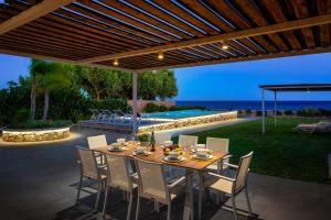 a table and chairs on a patio with a view of the ocean at Sea Homes Villas-Villa Sylvia in Kiotari