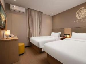a hotel room with two beds and a desk at Shell Hotel Beijing Shunyi District Shunyi Metro Station in Tahe