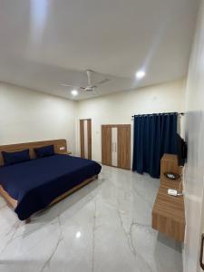 a bedroom with a bed with a blue comforter at ClubGreens in Jorhat