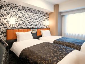 una camera d'albergo con due letti e una finestra di APA Hotel Nihombashi Bakuroyokoyama Ekimae a Tokyo