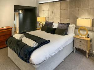 una camera da letto con un letto grande con lenzuola e cuscini bianchi di Otter Hollow a Middleton