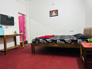 a bed sitting in a room with a tv at Cozy haven in Auroville +26 photos