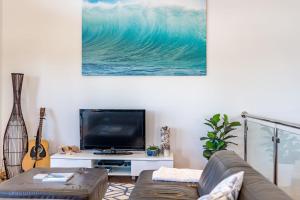 a living room with a couch and a large wave on the wall at 65 McLeod Rd Middleton Pet Friendly Wi-Fi - No Linen Included in Middleton