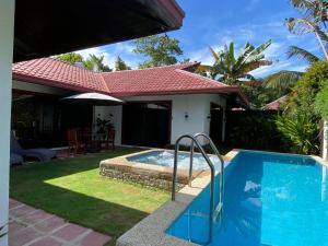 een huis met een zwembad in de tuin bij Villas Flora Bella Resort in Dauis