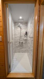 a glass door of a shower in a bathroom at Hakuba Loghouse in Hakuba +18 photos