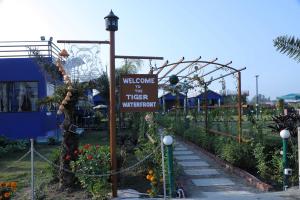 un cartello per un giardino con un benvenuto alla stregoneria dell'acqua di The Tiger Waterfront Resort a Mādho Tānda