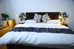 una camera da letto con un letto grande con lenzuola e cuscini bianchi di The Tiger Waterfront Resort a Mādho Tānda Altre 52 foto