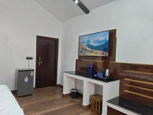 The Tiger Waterfront Resort في Mādho Tānda: غرفة بها مكتب وسرير وتلفزيون