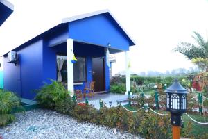The Tiger Waterfront Resort في Mādho Tānda: منزل أزرق اللون مع مصباح أمامه